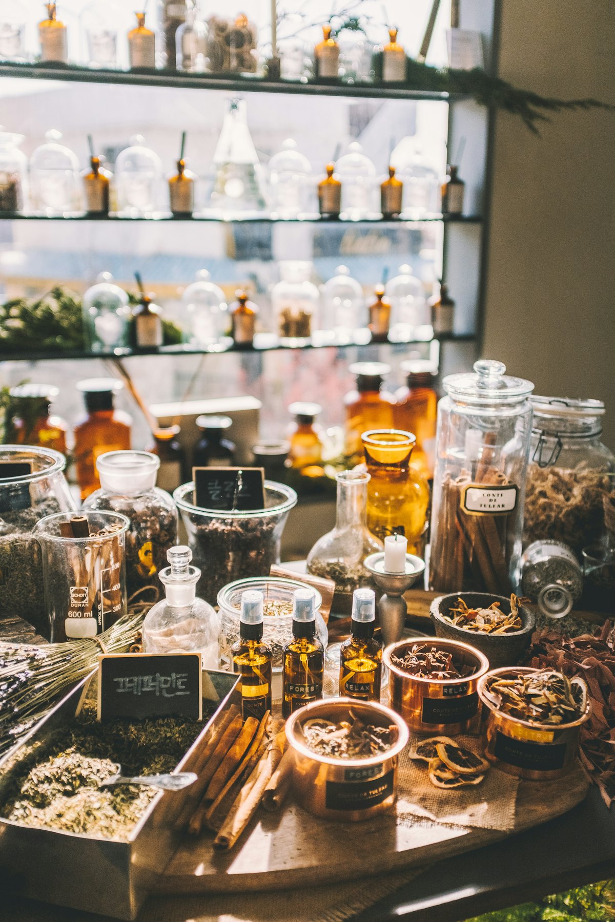 Glass jars of dried herbs and natural ingredients on an apothecary table
