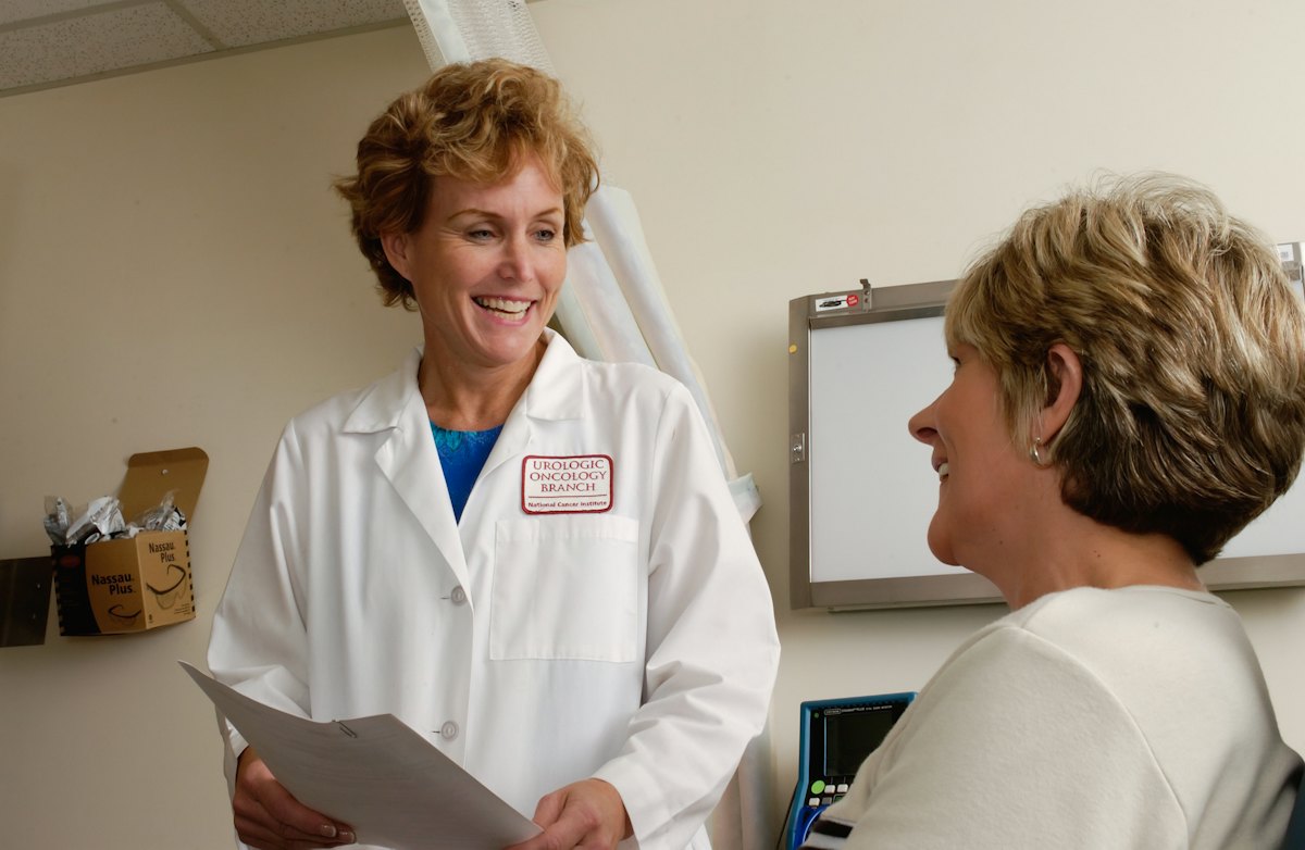 Doctor smiling while talking with a patient in a clinic room