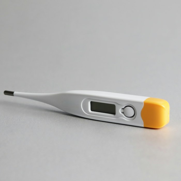 Digital thermometer on a grey background